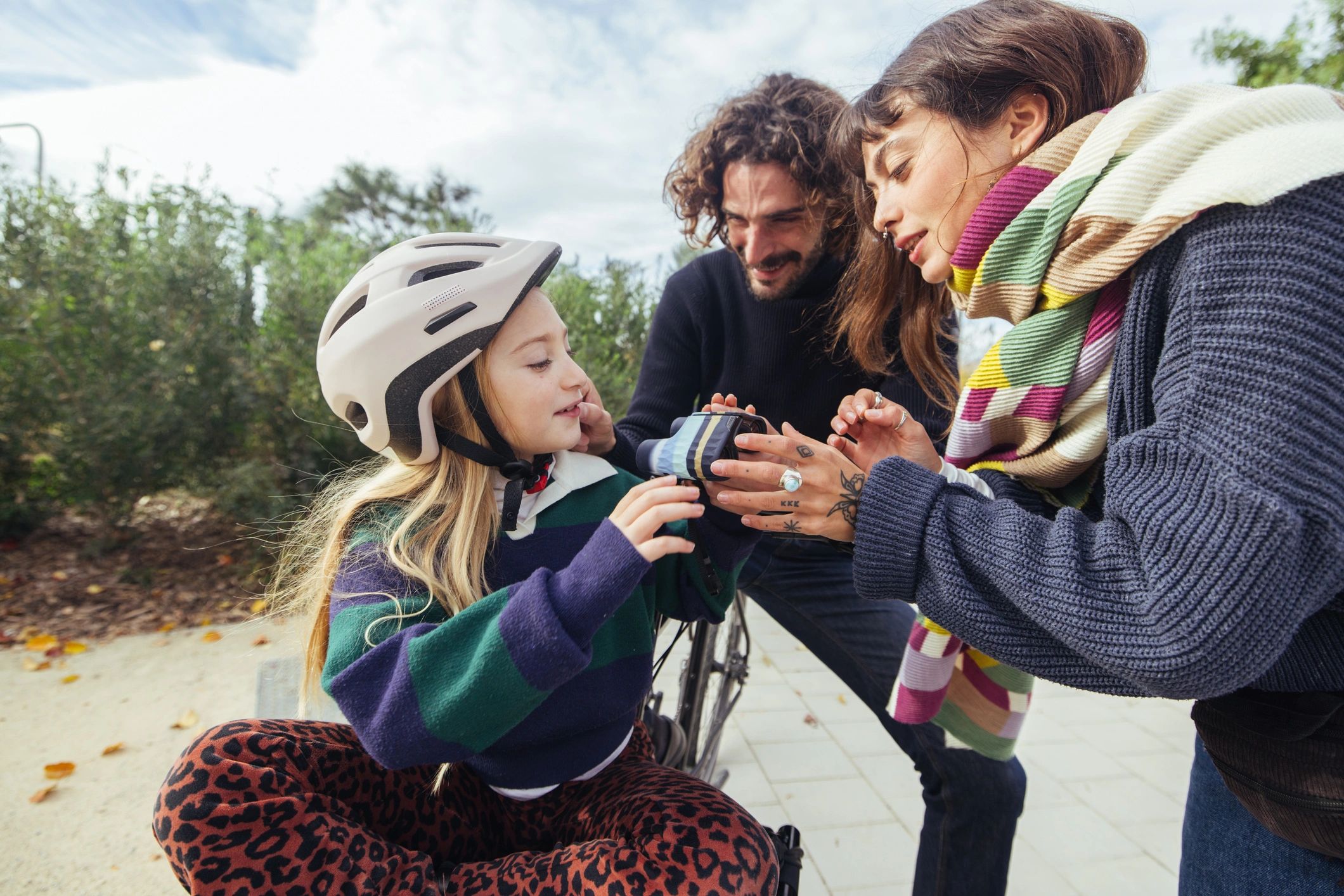 Parents sharing a relaxed outdoor family moment with their child